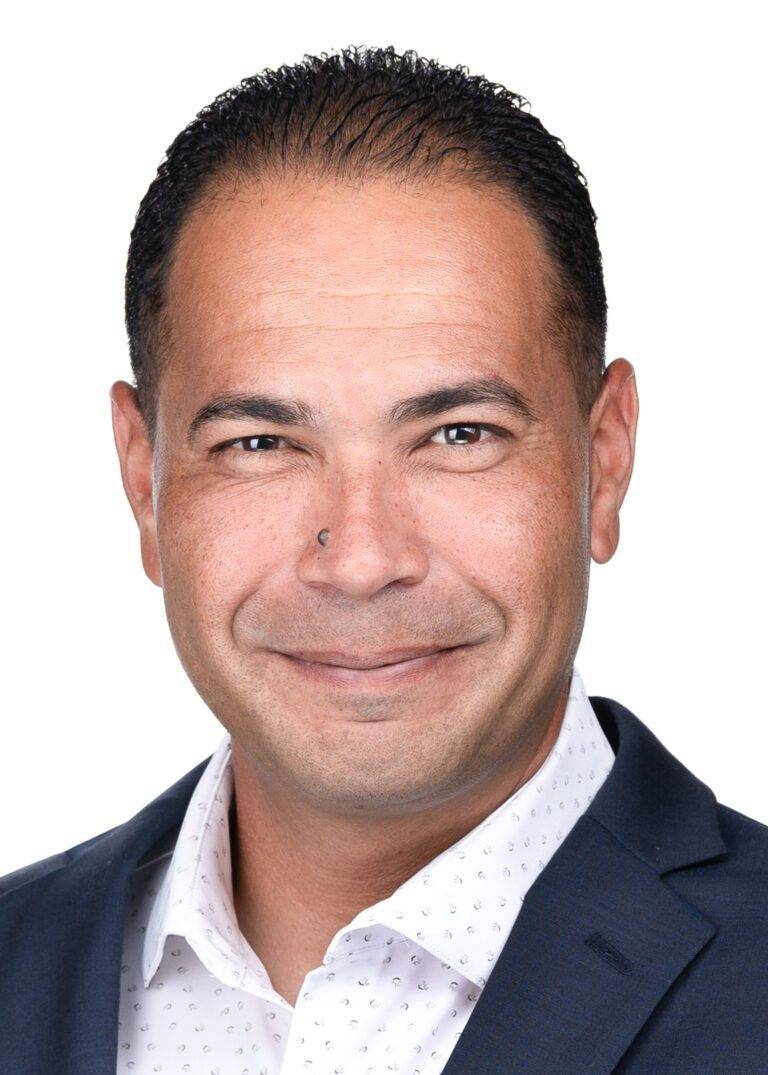 A professional photographer captures a corporate headshot of a smiling man in a suit and tie.