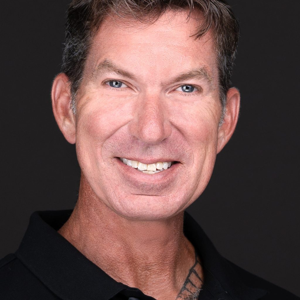 A man in a black shirt smiling for the camera during a business headshot session with professional photographer Sarah Anne Wilson Photography in Cary, North Carolina.