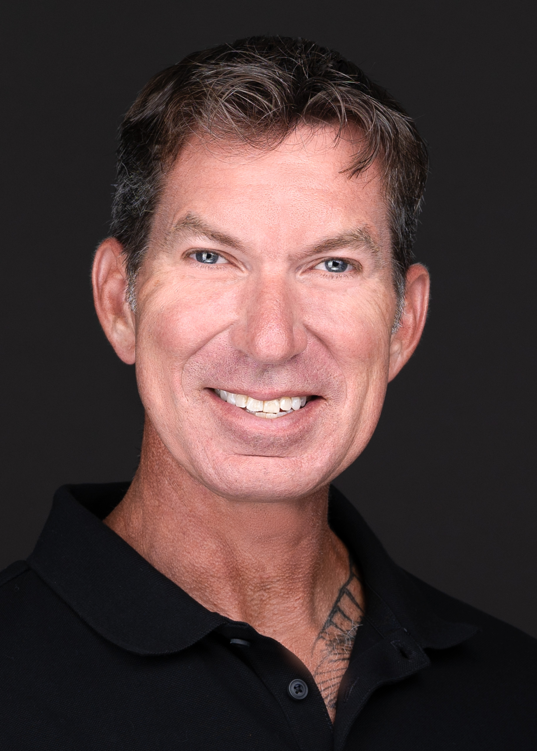 A man in a black shirt smiling for the camera during a business headshot session with professional photographer Sarah Anne Wilson Photography in Cary, North Carolina.