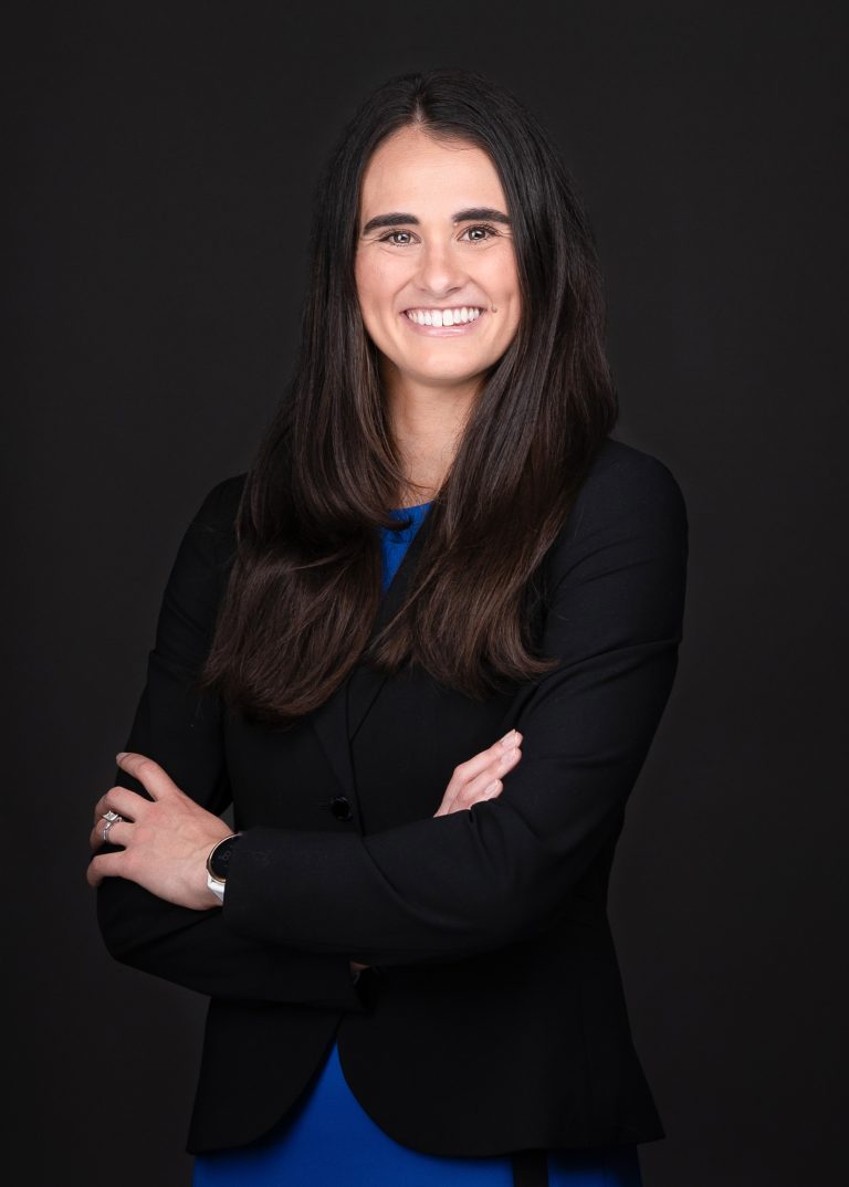 A woman in a black suit and blue dress posing for a photo captured by professional photographer Sarah Anne Wilson Photography near Cary North Carolina.