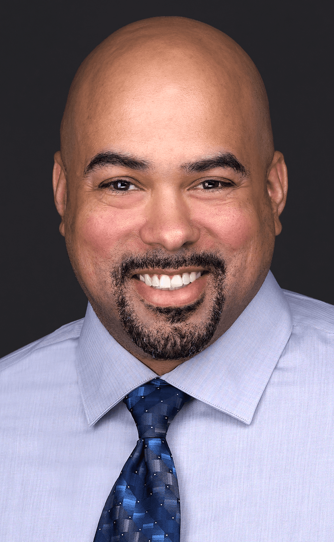 A corporate businessman wears a pastel purple shirt and blue tie as he sits for a professional headshot in the photography studio of Sarah Anne Wilson in Cary NC