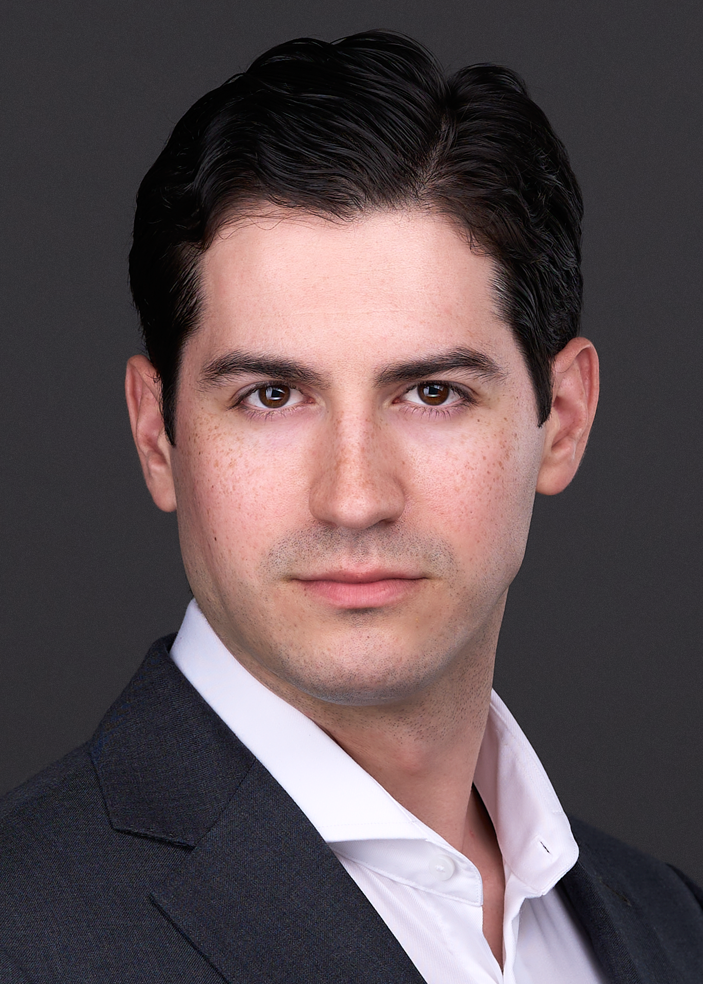 A business man wearing a blue suit, uses a serious expression while being photographed for his Professional Corporate Headshot in Raleigh NC