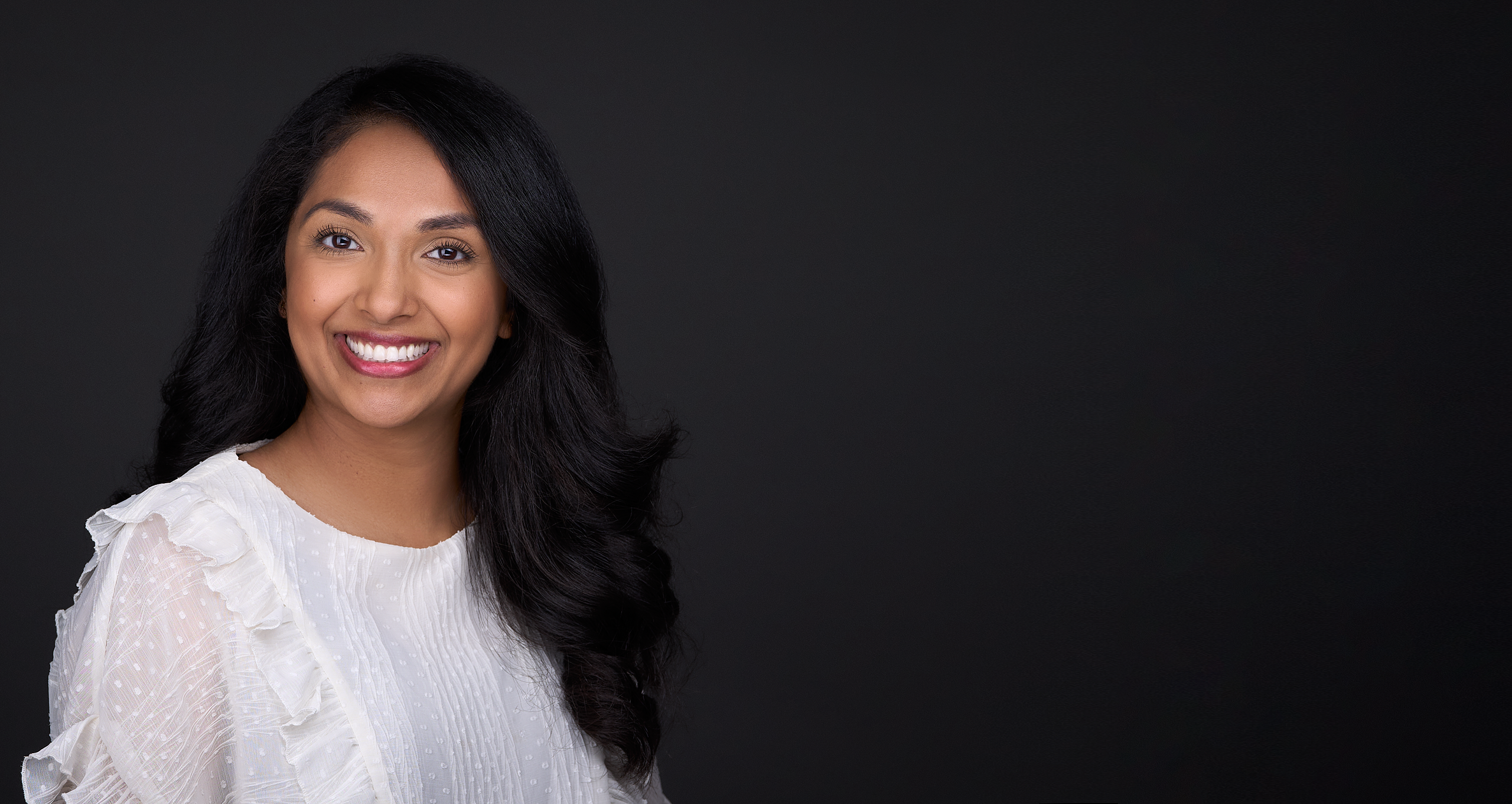 Portrait of a smiling brunette businesswoman formal dressed. Isolated on dark textured background.