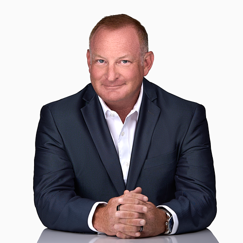 Man in a blue suit and white shirt poses for a professional headshot in a professional photography studio in Cary NC