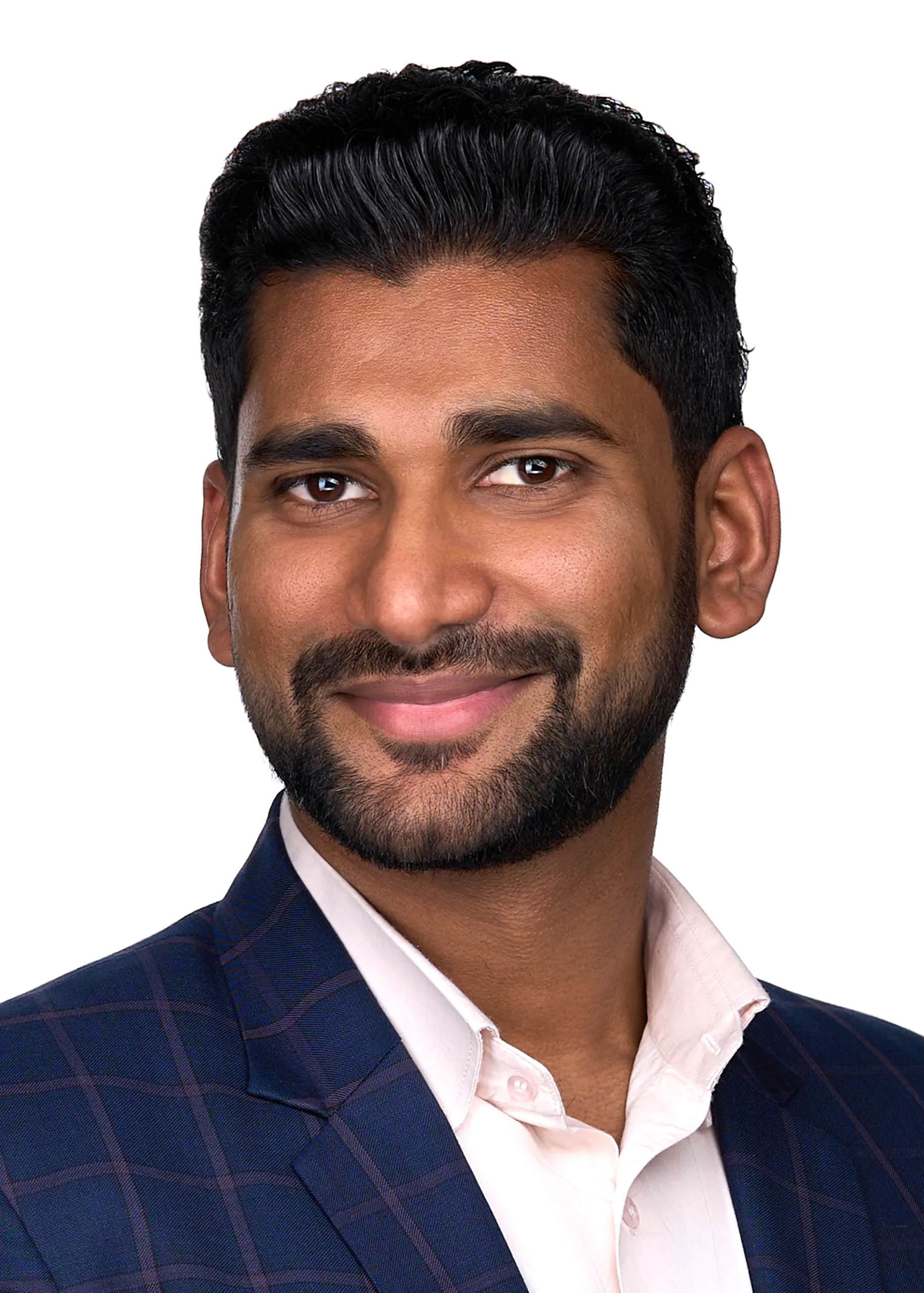 A man with a beard and mustache stands in front of a white backdrop as he poses for a personal branding headshot in a photography studio in Cary Nc