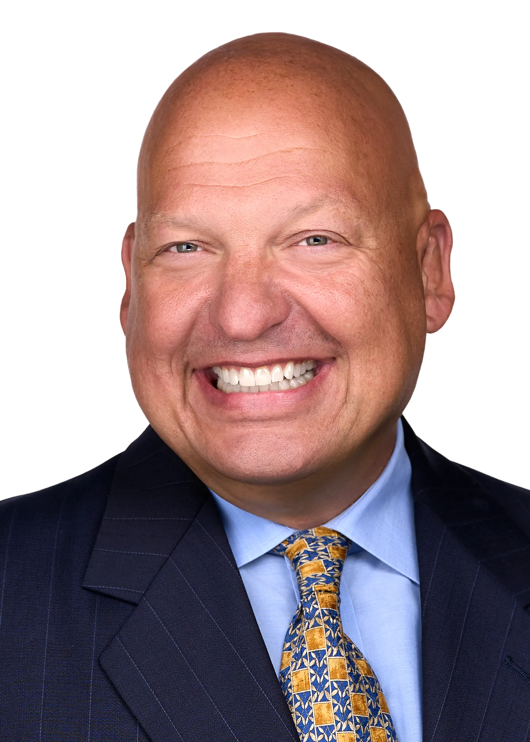 A man wearing a blue suite and yellow tie showcases his warm smile while being photographed for a professional headshot in Raleigh NC