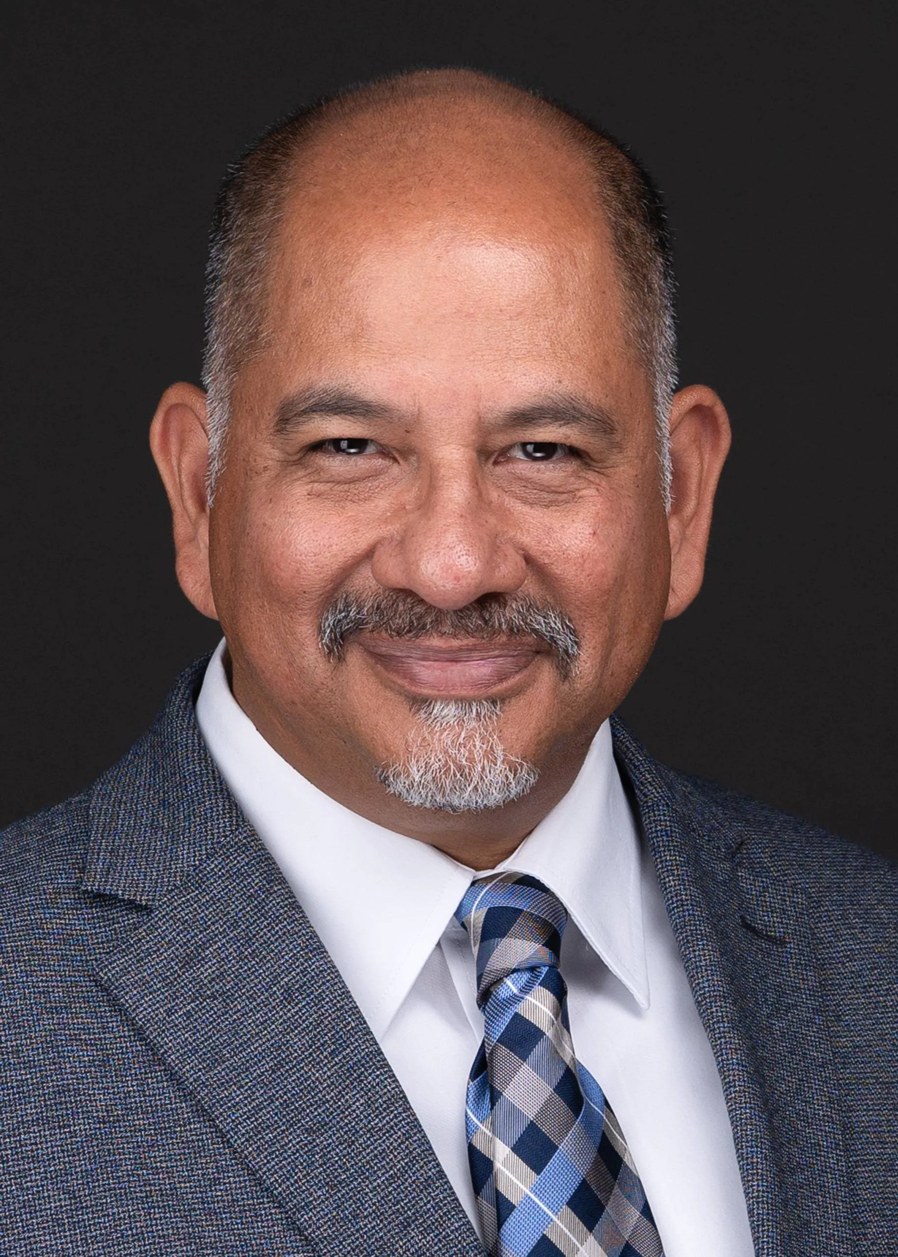 A professional photographer captures a headshot of a man in a suit and tie, showcasing his personal branding as he smiles for the camera.