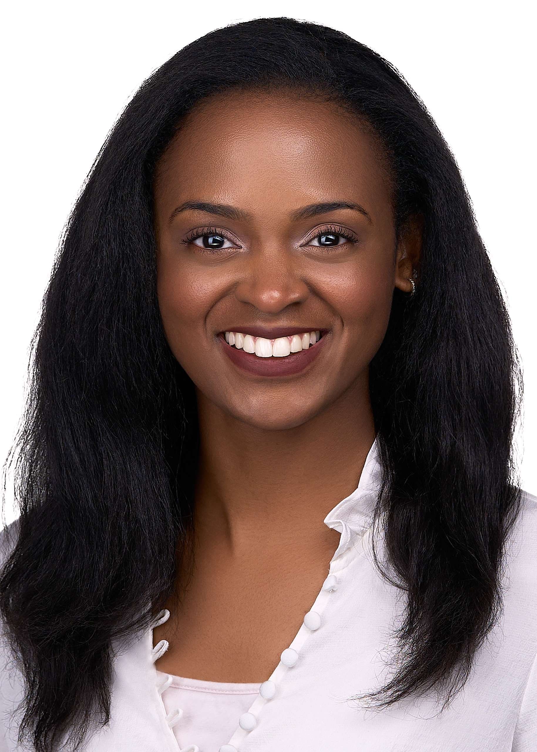 A young women with long brown hair wearing a white blouse poses for a professional headshot photographer in Cary NC