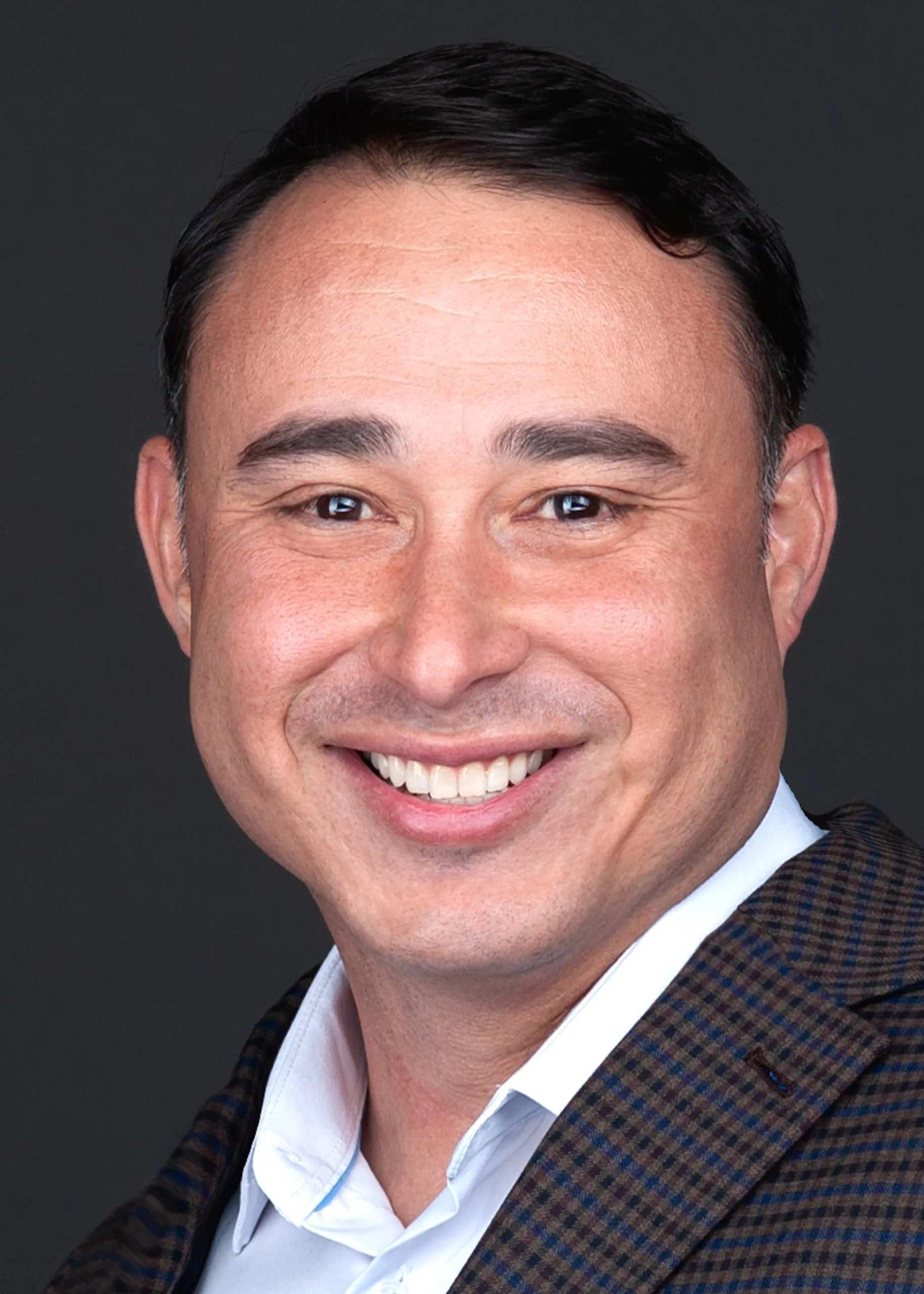 A man in a brown suit smiling for the camera during his corporate headshot session with Sarah Anne Wilson Photography in Cary, North Carolina.