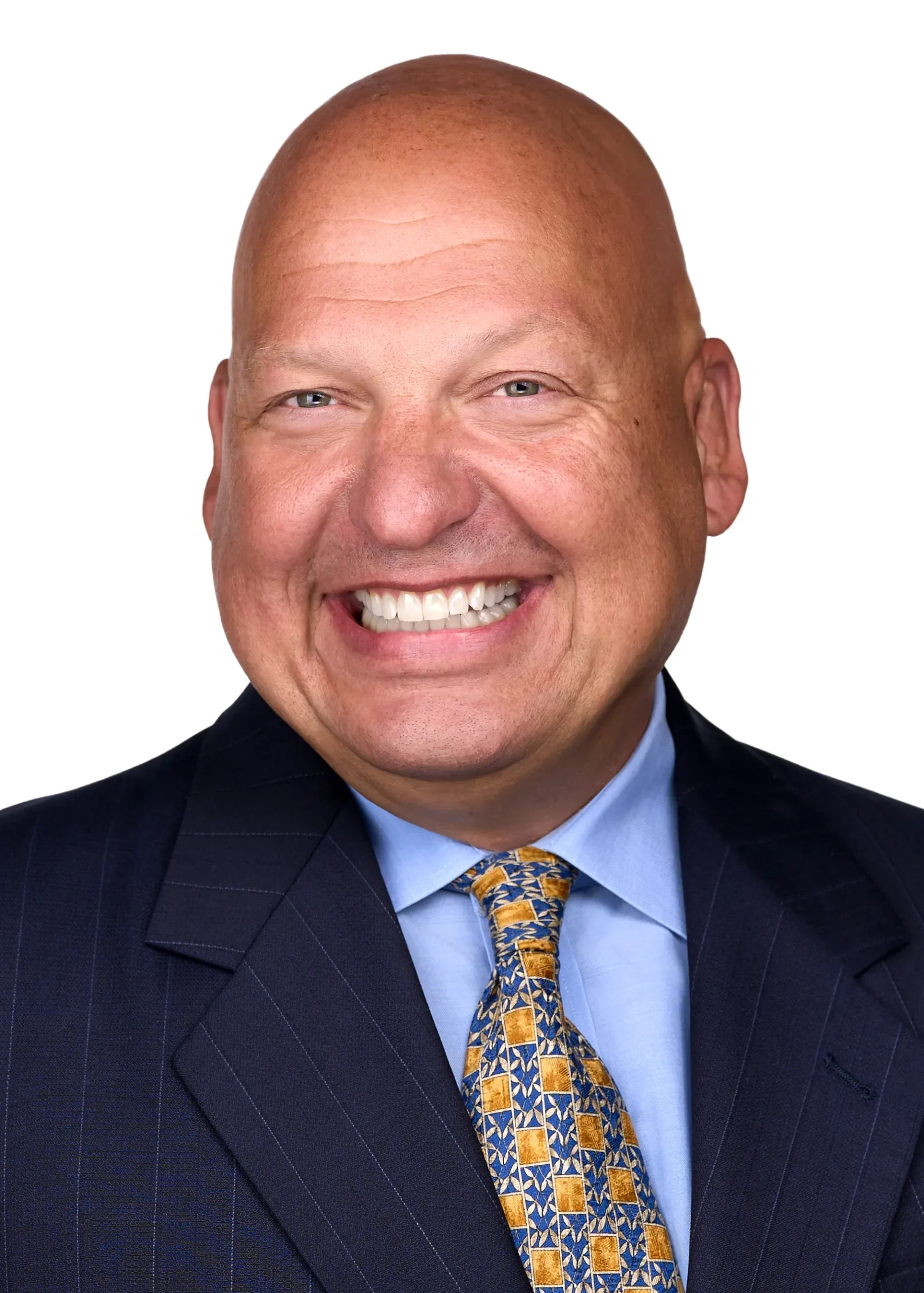 A man wearing a blue suite and yellow tie showcases his warm smile while being photographed for a professional headshot in Raleigh NC