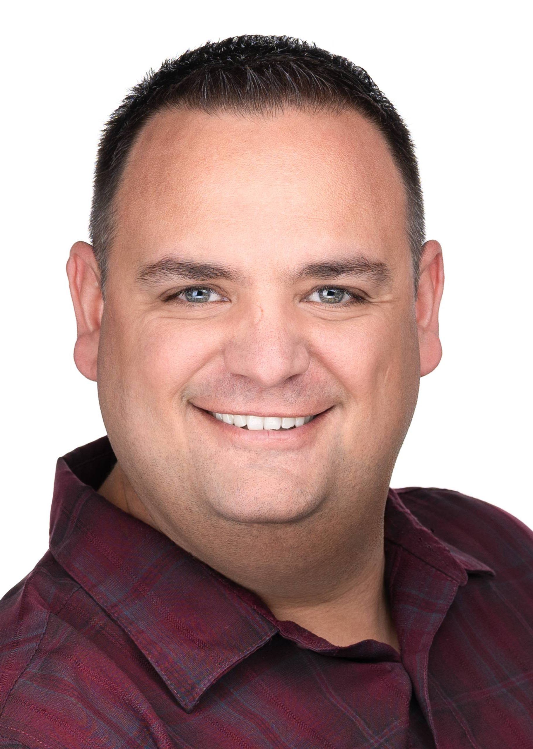 A professional photographer captures a man in a plaid shirt smiling for the camera, creating business headshots at Sarah Anne Wilson Photography in Cary, North Carolina.